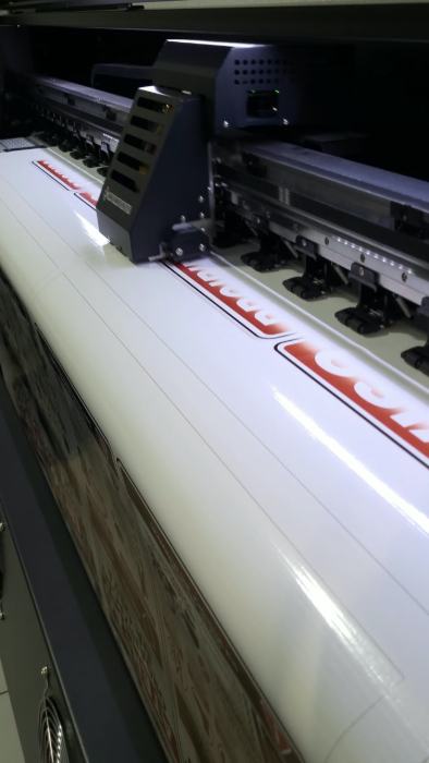 Impressora de grande formato produzindo adesivo